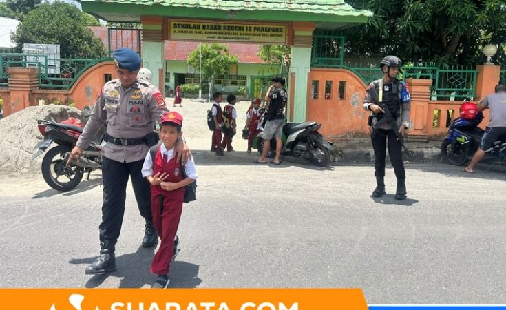Personel Brimob Batalyon B Pelopor Satuan Brimob Polda Sulsel Bantu Anak Sekolah Menyebrangi Jalan Padat Kendaraan